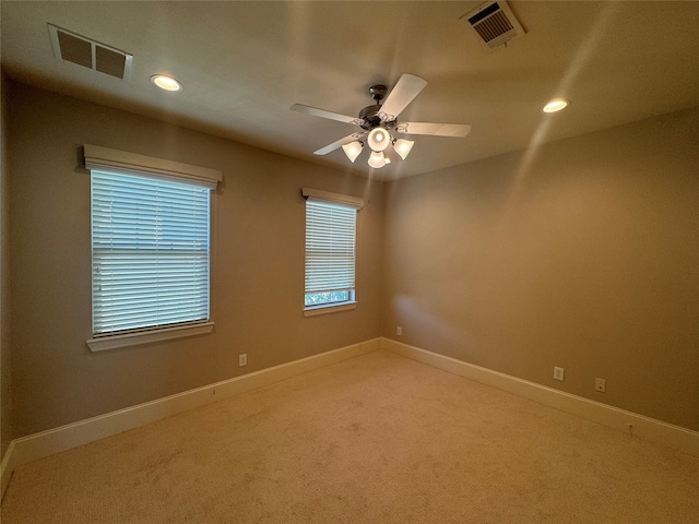 carpeted spare room featuring ceiling fan