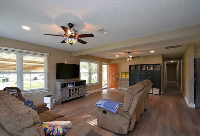 living room featuring ceiling fan, wood-type flooring, and a textured ceiling