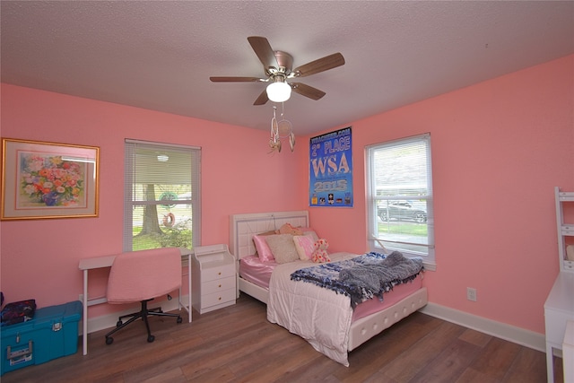 bedroom with a textured ceiling, ceiling fan, and dark wood-type flooring