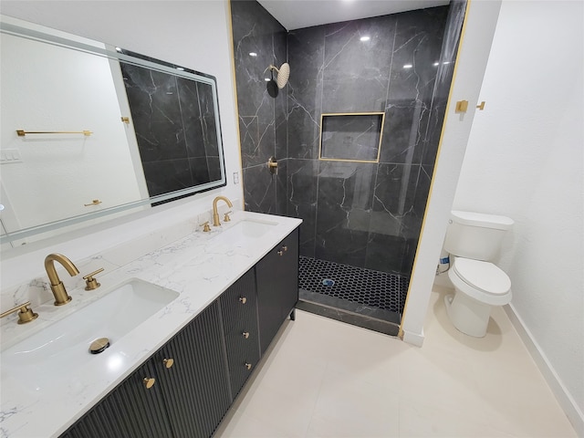 bathroom featuring tile patterned floors, vanity, toilet, and a tile shower