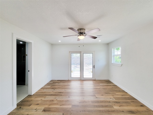 unfurnished room featuring ceiling fan, a textured ceiling, and light wood-type flooring