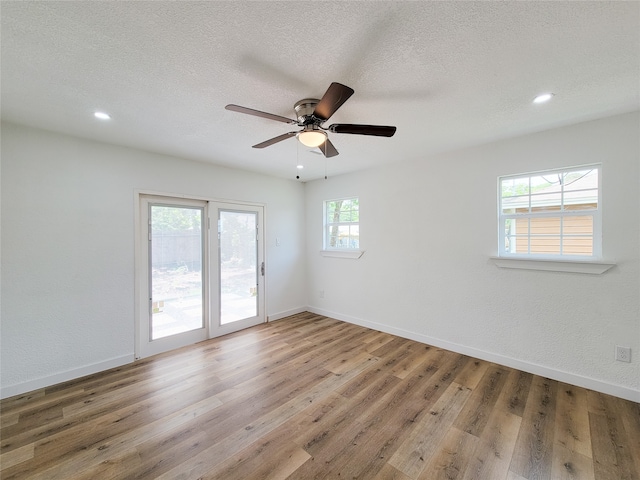 unfurnished room with wood-type flooring, a textured ceiling, and ceiling fan