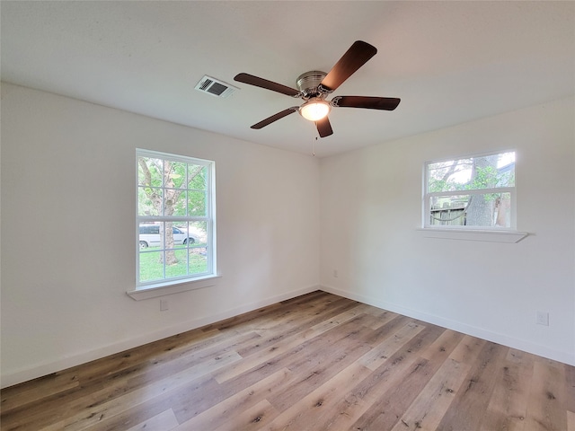 empty room with ceiling fan, a healthy amount of sunlight, and light wood-type flooring