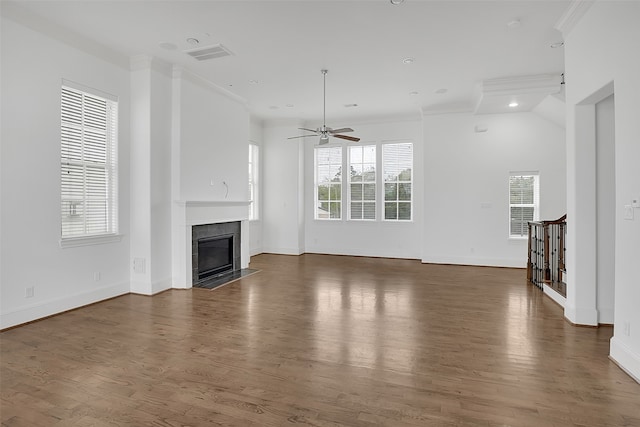 unfurnished living room with lofted ceiling, a tile fireplace, crown molding, ceiling fan, and dark hardwood / wood-style flooring