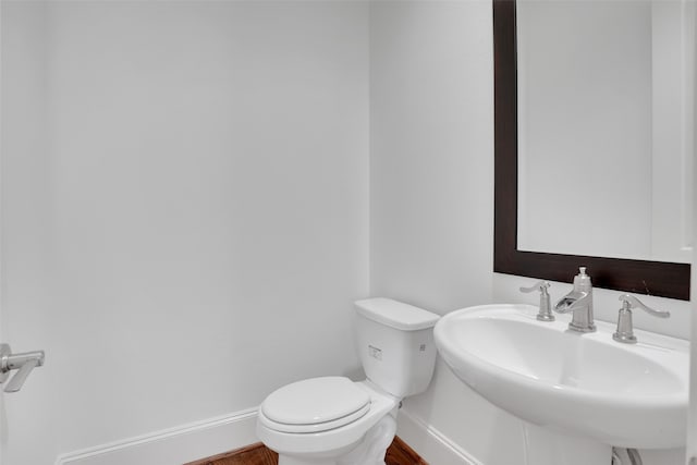 bathroom featuring toilet, wood-type flooring, and sink