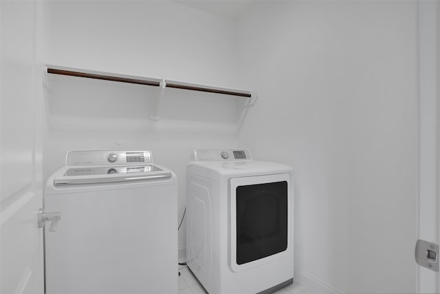 clothes washing area with light tile patterned floors and independent washer and dryer