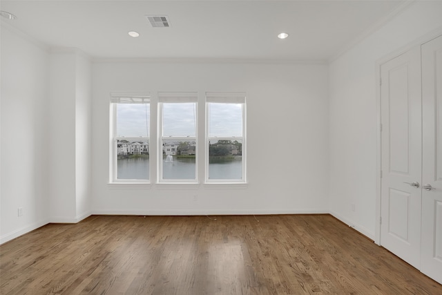 empty room featuring hardwood / wood-style floors and ornamental molding