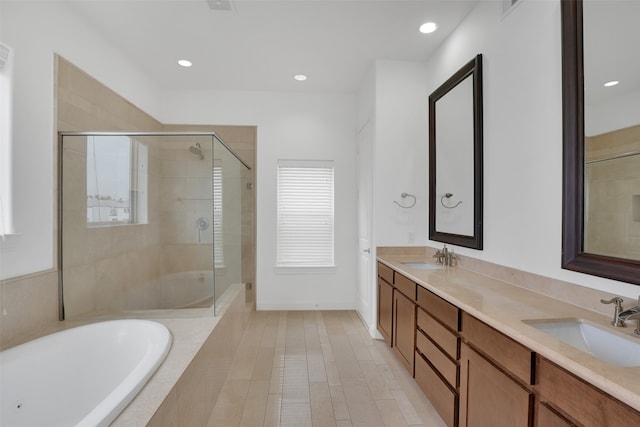 bathroom with vanity and shower with separate bathtub