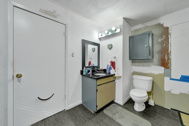 bathroom with vanity, a textured ceiling, hardwood / wood-style flooring, and toilet