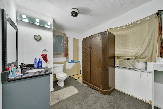 bathroom featuring vanity, wood-type flooring, a textured ceiling, and toilet