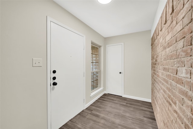 foyer entrance featuring hardwood / wood-style flooring and brick wall