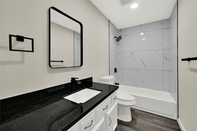 full bathroom featuring toilet, vanity, tiled shower / bath combo, and hardwood / wood-style flooring