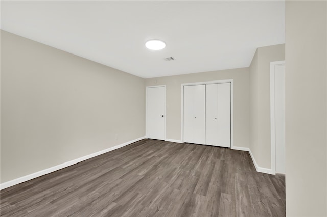 unfurnished bedroom featuring hardwood / wood-style flooring and a closet