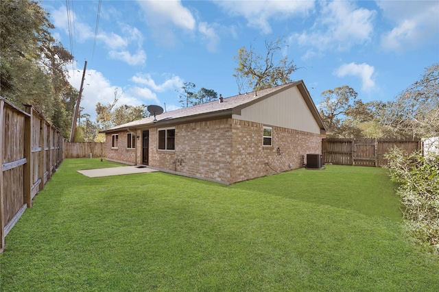 back of property featuring a lawn and central air condition unit