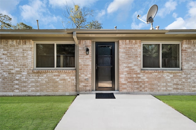 entrance to property with a yard and a patio