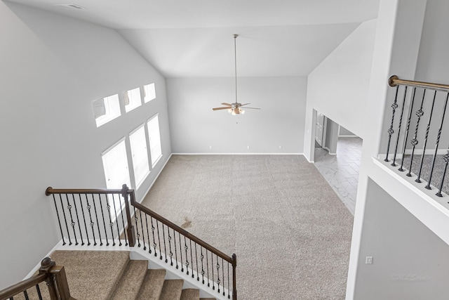 carpeted living room with a high ceiling and ceiling fan