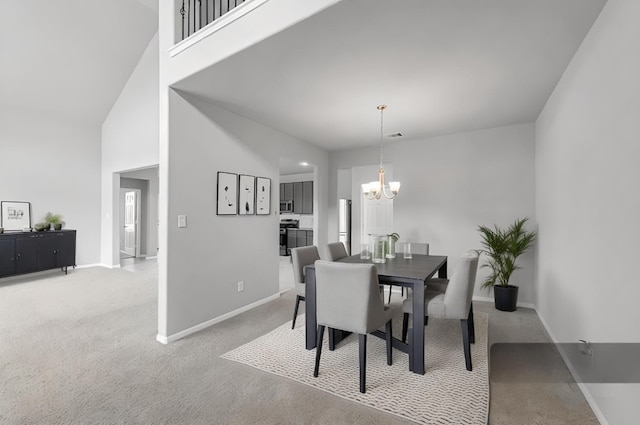 dining room featuring a towering ceiling, a chandelier, and light carpet