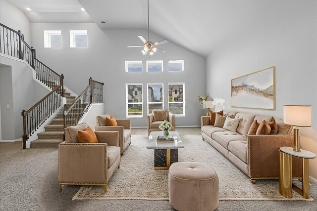 carpeted living room featuring ceiling fan and a towering ceiling