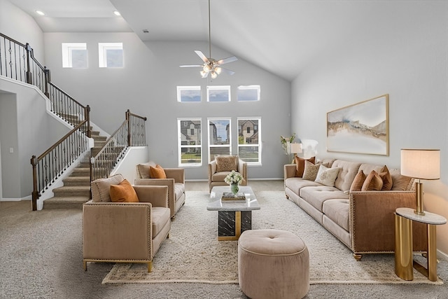 living room featuring a towering ceiling, light colored carpet, and ceiling fan