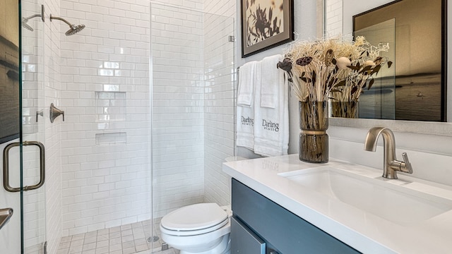 bathroom with vanity, toilet, and a shower with door