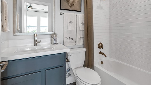 full bathroom with tiled shower / bath, vanity, and toilet