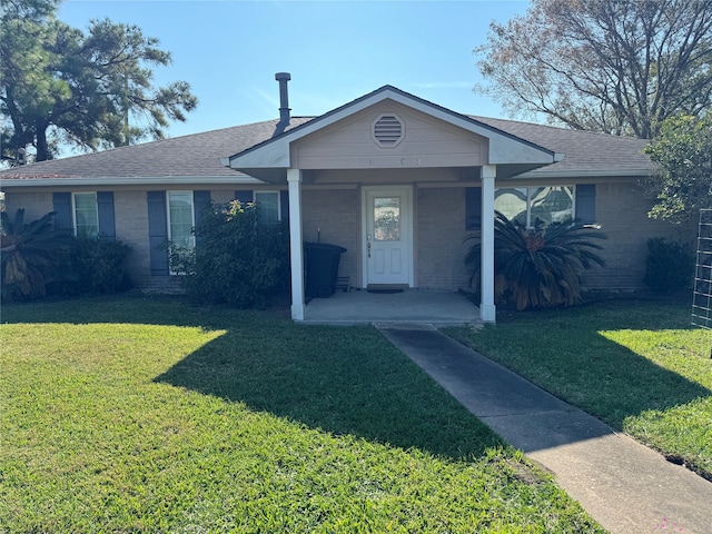 ranch-style home featuring covered porch and a front lawn