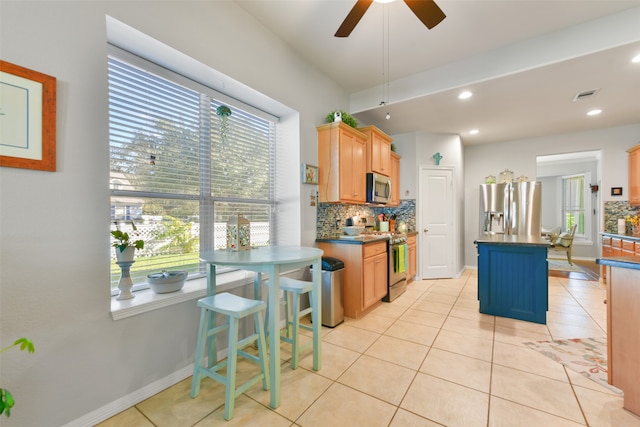 kitchen featuring backsplash, a center island, a healthy amount of sunlight, and appliances with stainless steel finishes