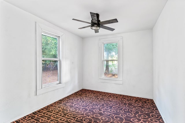 carpeted spare room with plenty of natural light and ceiling fan