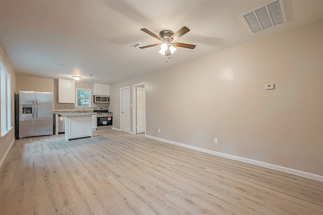 kitchen featuring white cabinets, sink, ceiling fan, light wood-type flooring, and appliances with stainless steel finishes