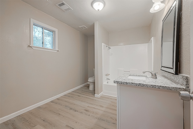 full bathroom with hardwood / wood-style floors, vanity, shower / bath combination, and toilet