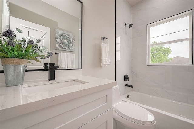 full bathroom featuring vanity, tiled shower / bath combo, and toilet