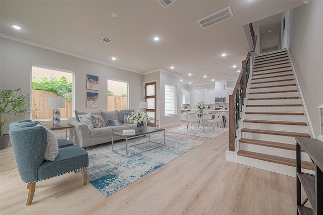 living room with light wood-type flooring and crown molding