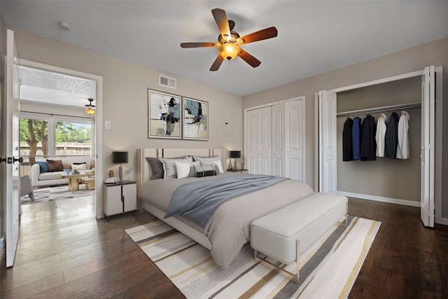 bedroom featuring ceiling fan, dark hardwood / wood-style floors, and two closets