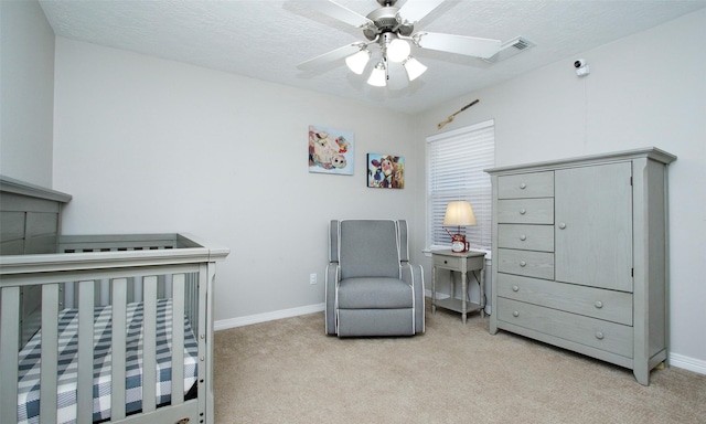 bedroom featuring ceiling fan, light carpet, and a textured ceiling