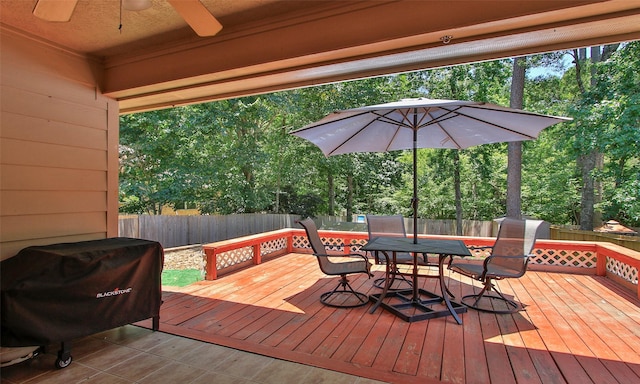 wooden deck with grilling area and ceiling fan