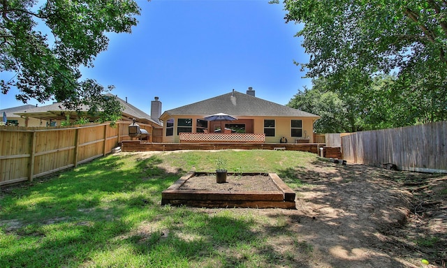 back of house with a deck and a lawn