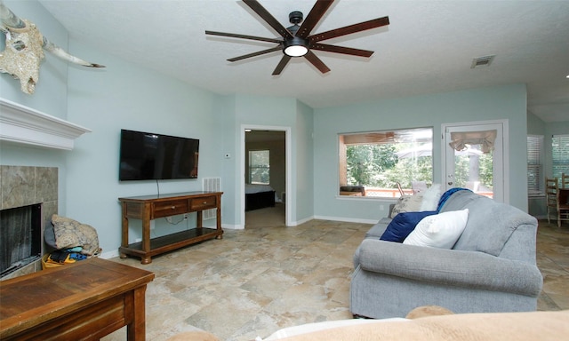 living room featuring ceiling fan and a fireplace