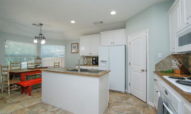 kitchen with pendant lighting, white cabinetry, sink, a kitchen island with sink, and white appliances