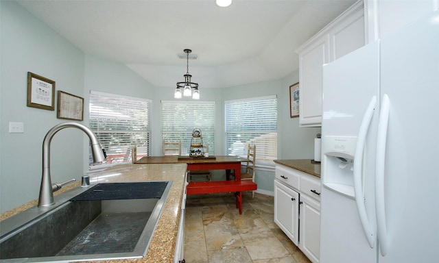 kitchen featuring white cabinetry, sink, decorative light fixtures, and white fridge with ice dispenser