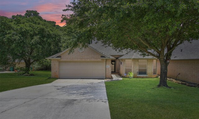 ranch-style home with a yard and a garage