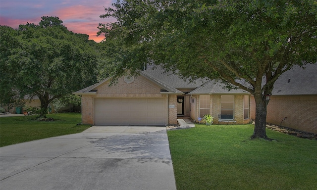 single story home with a garage and a yard