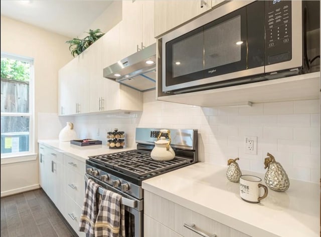 kitchen with white cabinets, decorative backsplash, dark hardwood / wood-style flooring, and appliances with stainless steel finishes