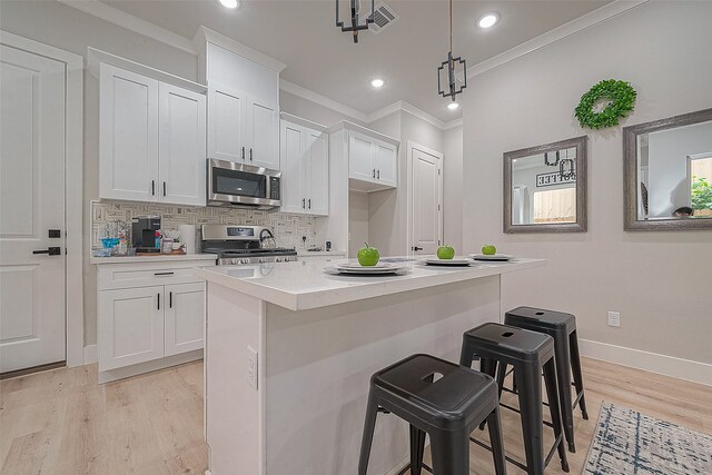 3837 Mainer St, Houston, TX 77021 - kitchen with white cabinets, appliances with stainless steel finishes, decorative light fixtures, and a breakfast bar area