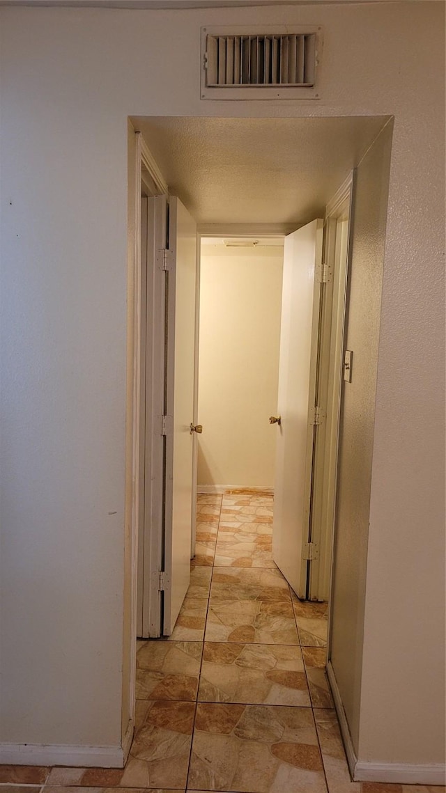 hallway with a textured ceiling