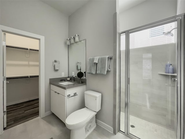 bathroom featuring vanity, toilet, and a shower with shower door