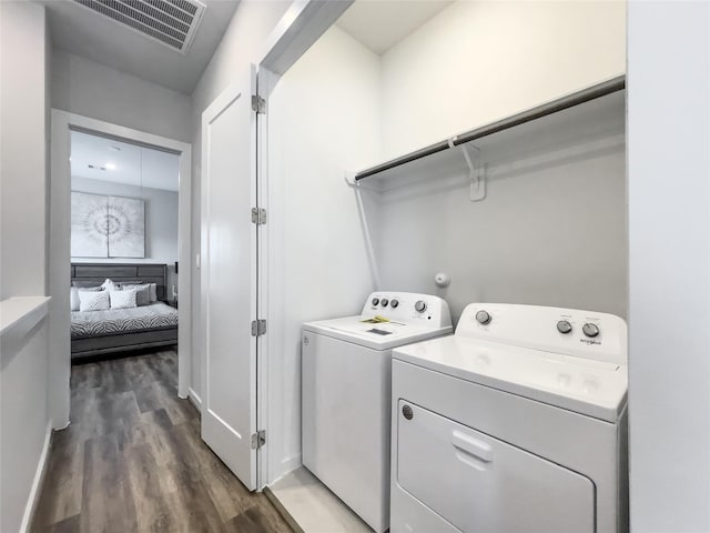 clothes washing area featuring washer and dryer and dark hardwood / wood-style floors