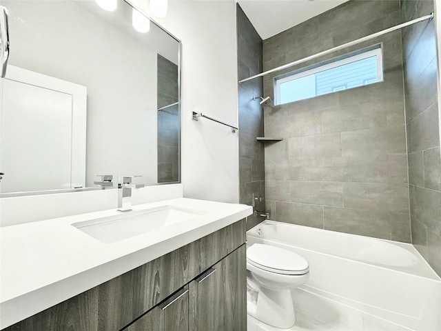 full bathroom with tile patterned floors, vanity, tiled shower / bath combo, and toilet