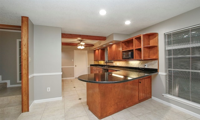 kitchen featuring kitchen peninsula, decorative backsplash, light tile patterned floors, and sink