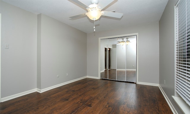 unfurnished bedroom with a textured ceiling, dark hardwood / wood-style floors, a closet, and ceiling fan