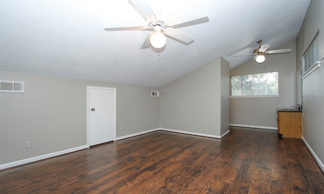 bonus room featuring ceiling fan, dark hardwood / wood-style flooring, a textured ceiling, and vaulted ceiling